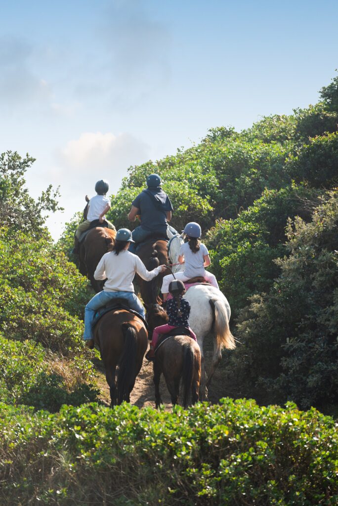 People at Seaton on horseback, riding through the bush